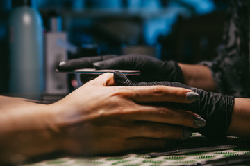Woman in a nail salon receiving a manicure by a beautician