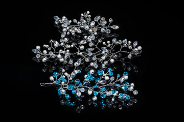 Handmade bead jewelry. Jewelry for a wedding hairstyle and any celebration in the form of a twig. Decoration on a black glossy background.