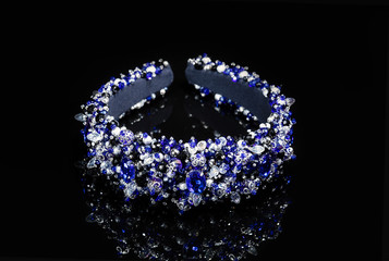 Stylish bead rim of different sizes on a black glossy background. The decoration is embroidered...