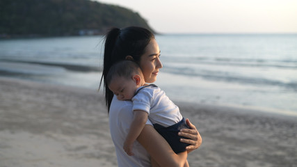 Holiday concept. Mother lulled the baby to sleep on the beach. 4k Resolution.