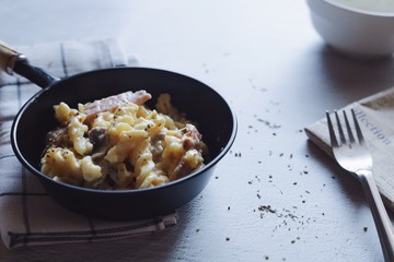 frying pan with meat and pasta cheese.