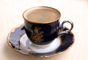 Cup of coffee on saucer on the  white napkin