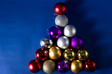 2020 New Year Alternative Christmas trees blue, silver, red Christmas-tree decorations-balls lying on a blue background. Close-up, horizontal layout, copy space.