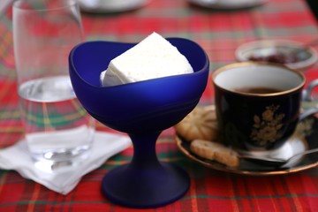 Ice cream in blue glass cup, coffee cup and clean water glass on the table