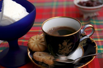 Dish with jam, cup with coffee and cookies, blue cup with ice cream, glass with water, teaspoon