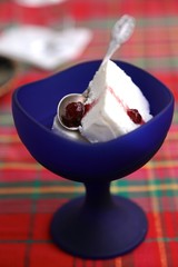 White ice cream with jam in blue glass cup