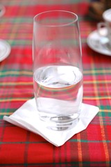 Glass with clean cold water on white napkin