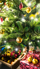 selective focus of a beautiful decorated Christmas tree with ornaments and lights and presents underneath