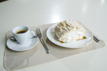 A delicious roll of bezrukov and a cup of coffee on a table in a cozy coffee shop