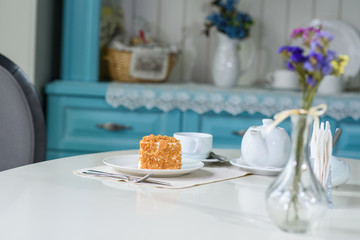 Delicious carrot cake and a cup of black tea on the table in a cozy coffee shop