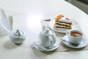 Delicious carrot cake and a cup of black tea on the table in a cozy coffee shop