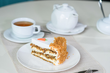 Delicious carrot cake and a cup of black tea on the table in a cozy coffee shop