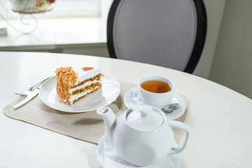 Delicious carrot cake and a cup of black tea on the table in a cozy coffee shop