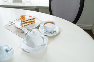 Delicious carrot cake and a cup of black tea on the table in a cozy coffee shop