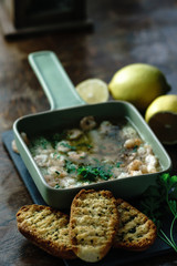 Shrimps, coctail prawns  in olive oil with garlic and parsley, spanish style tapas with toast on rustic wooden background.