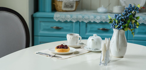 Danish with cherries and black tea on a table in a cozy coffee shop