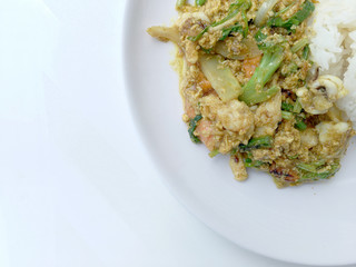 Stir fry mixed-seafood with with yellow curry powderin thai style with fried egg and rice in in white plate on white background.