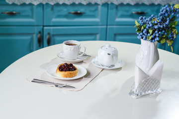 Danish with cherries and black tea on a table in a cozy coffee shop
