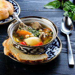 homemade shurpa soup on a black table