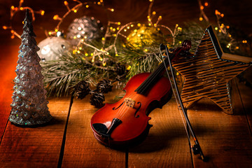 Exposition of violin and background with Christmas tree with light and candles, very beautiful composition, the best day in the year.
