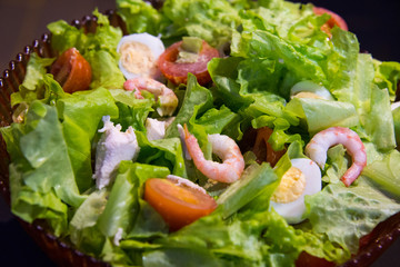 Tomatoes, shrimps, eggs and green salad. Closeup