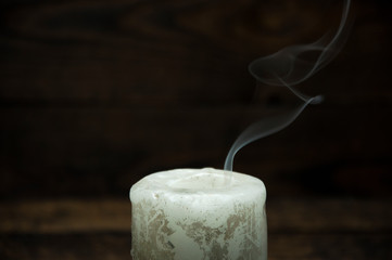 Smoke from a large extinct candle. In the dark on a black background.