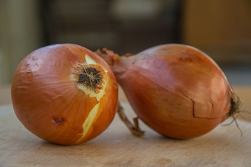Close-up of two brown onions on wooden table, kitchen, healthy food, vegetarian