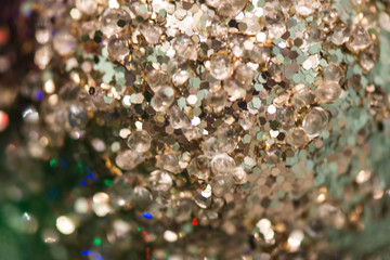 Festive background in the form of a scattering of silver breads and sequins. Closeup. Christmas concept. Selective focus