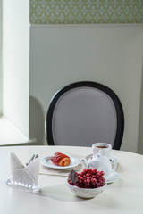 Cake with strawberries and black tea on the table in a cozy coffee shop
