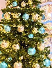 Obraz na płótnie Canvas Christmas tree with golden and turquoise balls and lots of little lights.