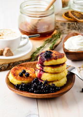 Fritters of cottage cheese with blueberries in plate, closeup