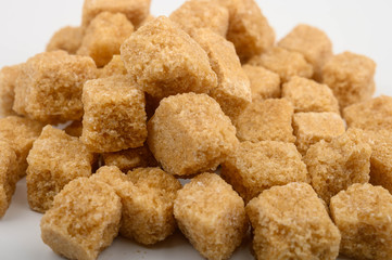 A bunch of brown sugar pieces on a white background close-up.