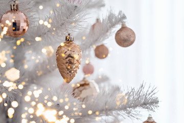 Decorated christmas tree with pink and golden toys on white background. Christmas concept, 2020.