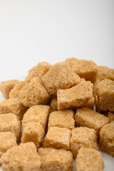 A bunch of brown sugar pieces on a white background close-up.