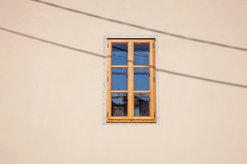 closed window in the middle of the beige wall.