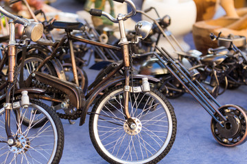 Fototapeta na wymiar collection of little models of old steel bicycles displayed in an antiques market