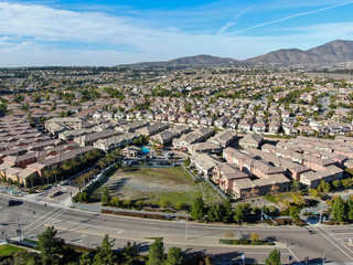 Aerial view of upper middle class neighborhood with identical residential subdivision houses during sunny day in Chula Vista, California, USA.
