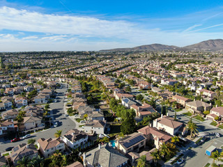 Obraz premium Aerial view of upper middle class neighborhood with identical residential subdivision houses during sunny day in Chula Vista, California, USA.