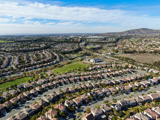 Fototapeta na wymiar Aerial view of upper middle class neighborhood with identical residential subdivision houses during sunny day in Chula Vista, California, USA.