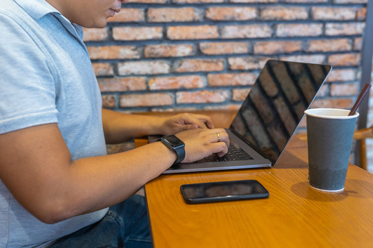 Asian businessman using laptop and smartphone at coffee table  - Powered by Adobe