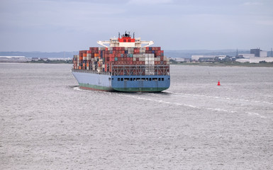 Konzept internationaler Handel: Sehr großes Containerschiff verlässt den Hafen in Richtung...
