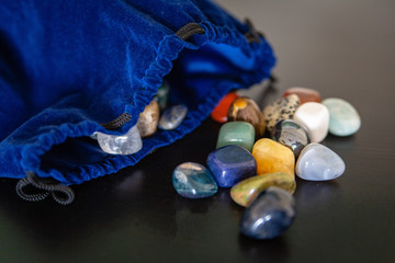 colorful semiprecious stones with a blue sack for energetic healing