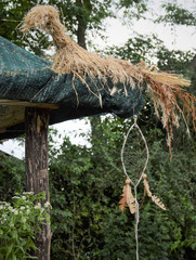 handmade dreamcatcher made of environmental materials under the roof of the house