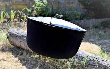 cauldron for cooking fish soup over an extinct fire