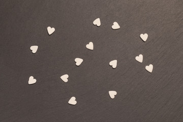 Corazones blancos sobre fondo negro de pizarra