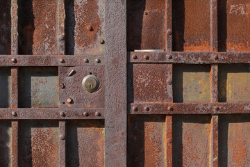 Closeup of old rusty metal lock and keyhole on a old iron door as a beautiful vintage background. Fragment of old rusty gate.