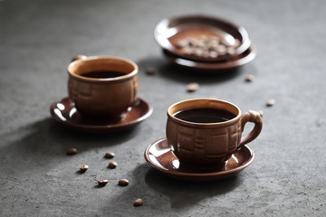 Still life black coffee in a Cup with coffee beans on a dark background