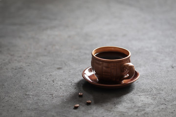 Still life black coffee in a Cup with coffee beans on a dark background