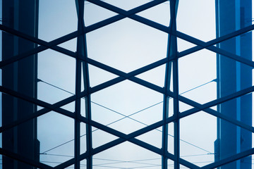 Close-up fragment of glass wall or roof panels. Minimalist business building interior. Abstract modern architecture background with polygonal hi-tech geometric structure of windows pattern.