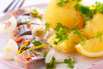 pieces of salted herring in spices with boiled potatoes